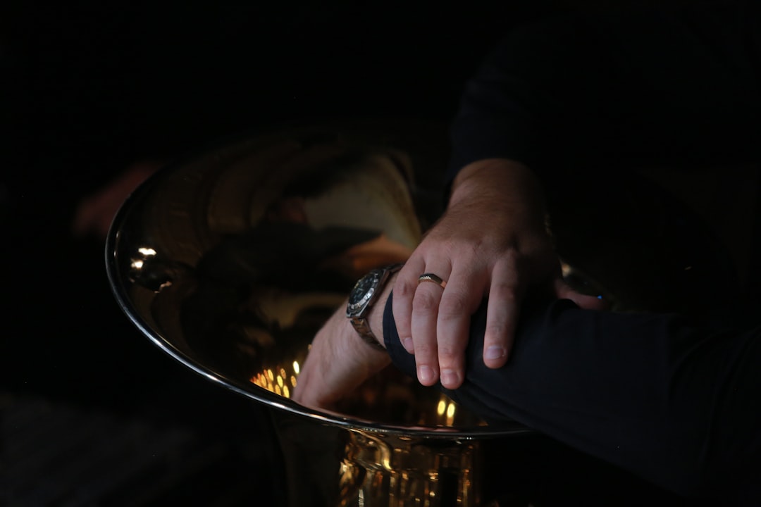 human hands with round silver-colored watch