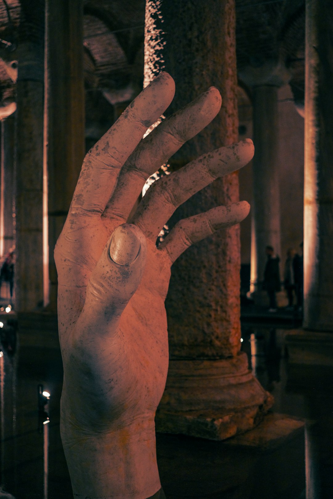 A hand statue inside of a dark cathedral.