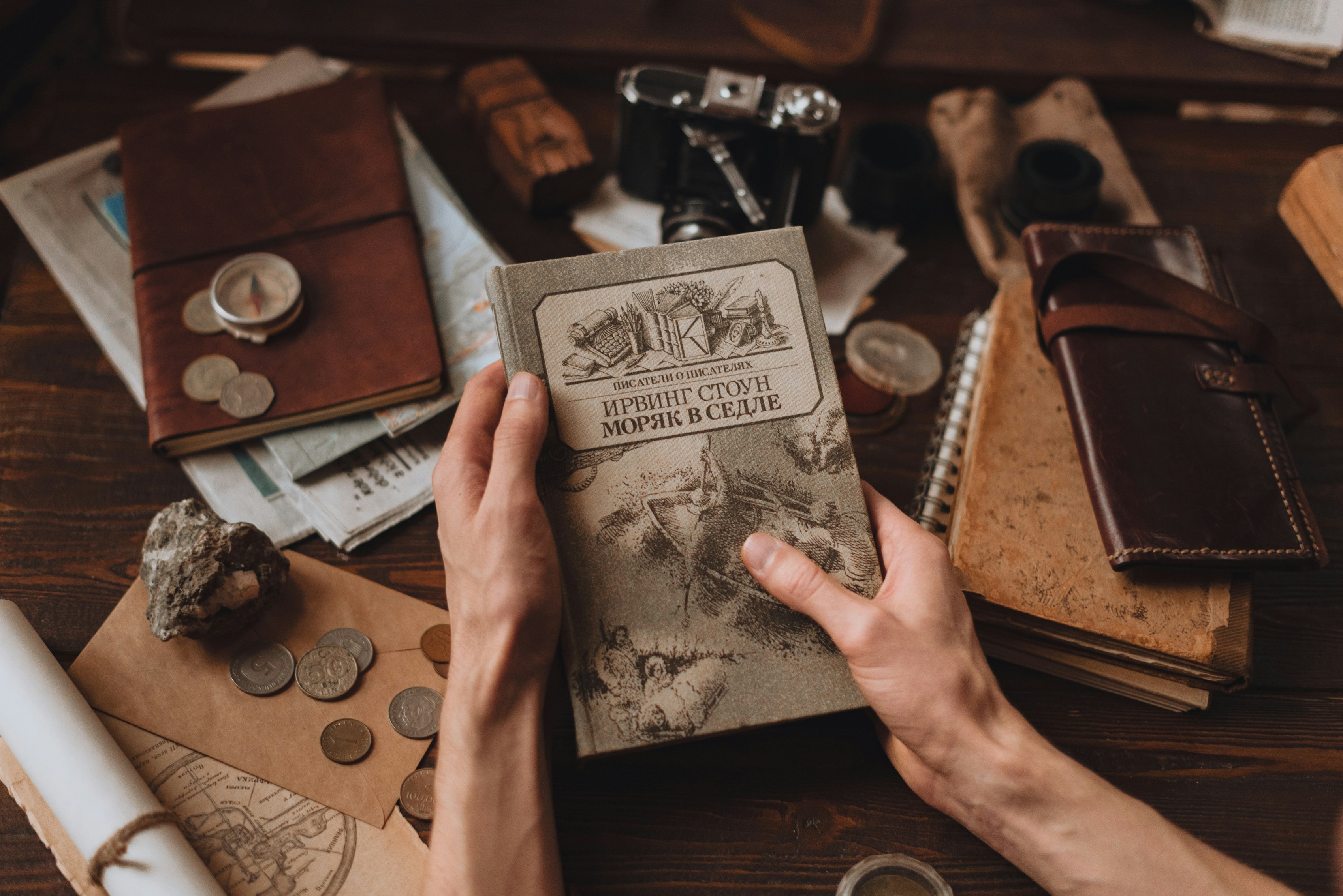 person holding a book with a silver watch