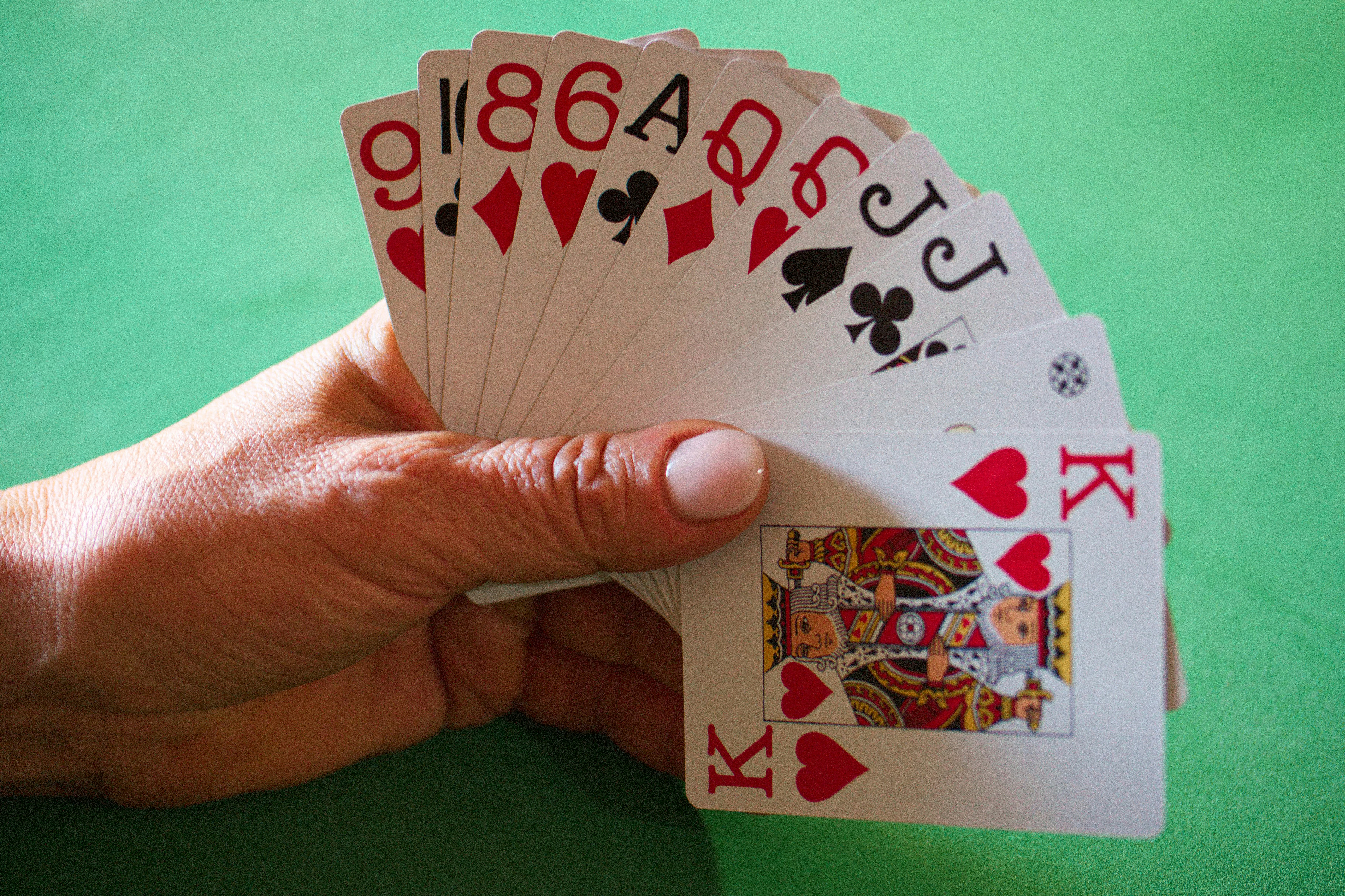 a person holding four playing cards in their hand
