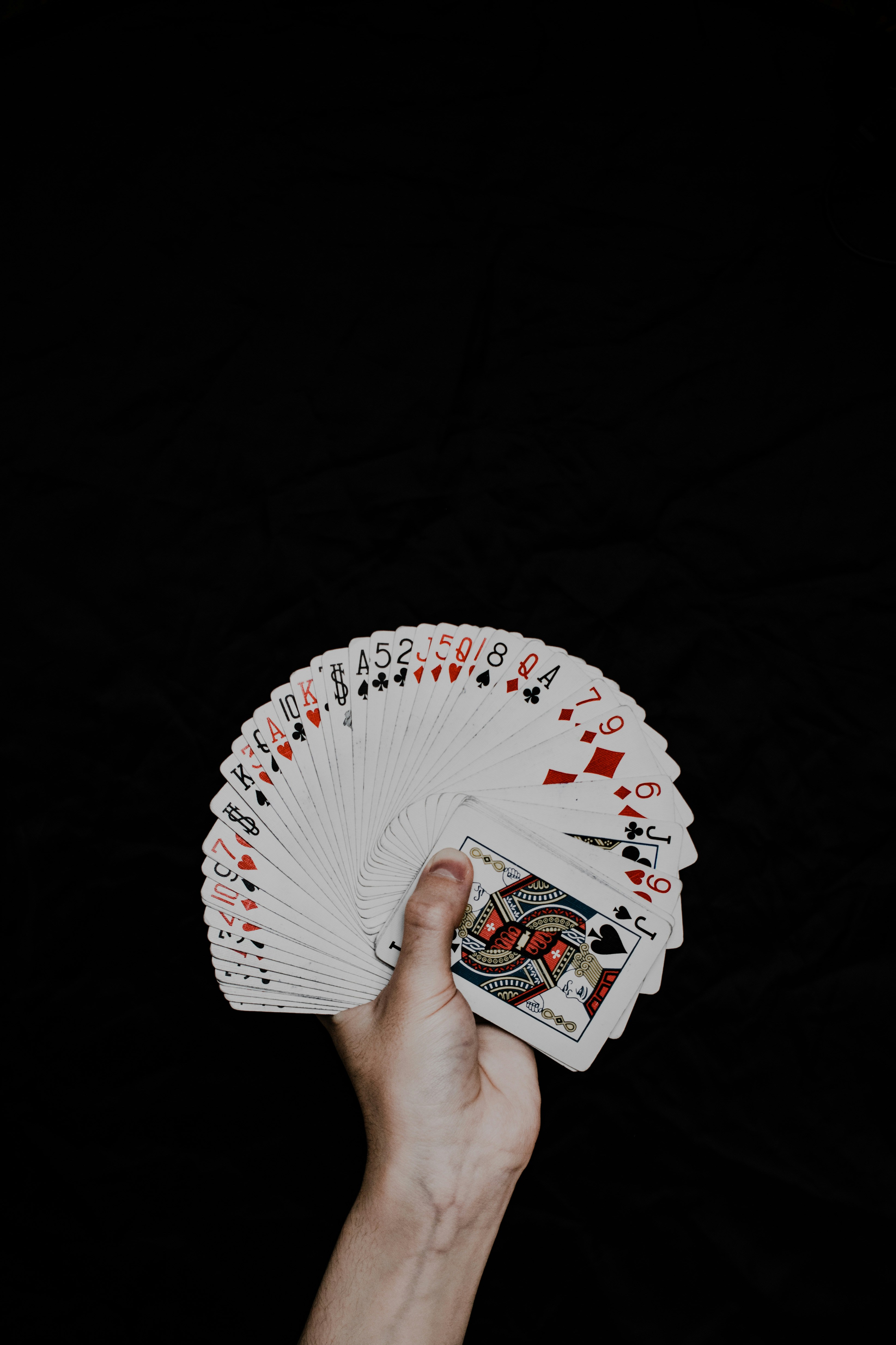 a hand holding a deck of playing cards