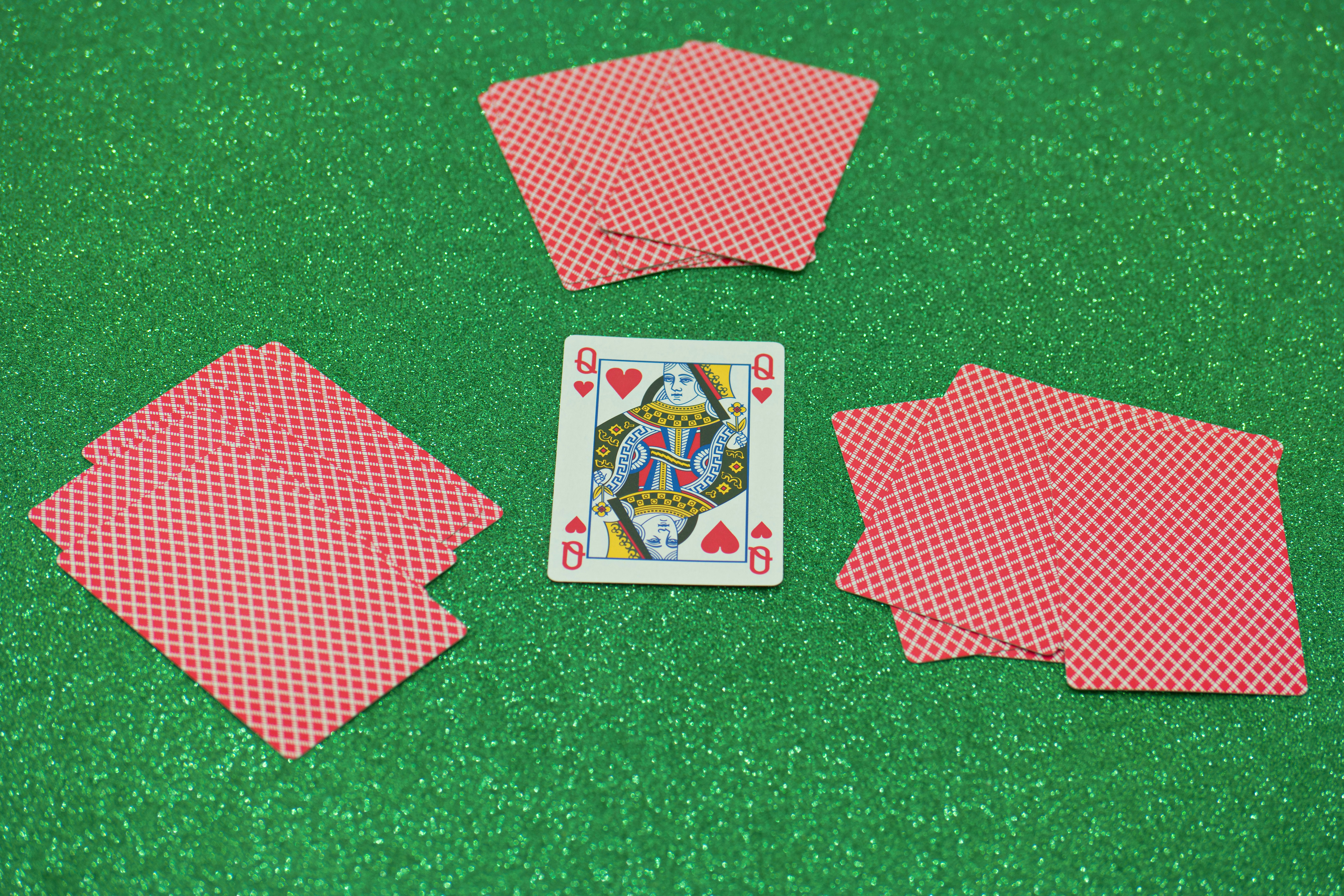 a set of four playing cards sitting on top of a green table