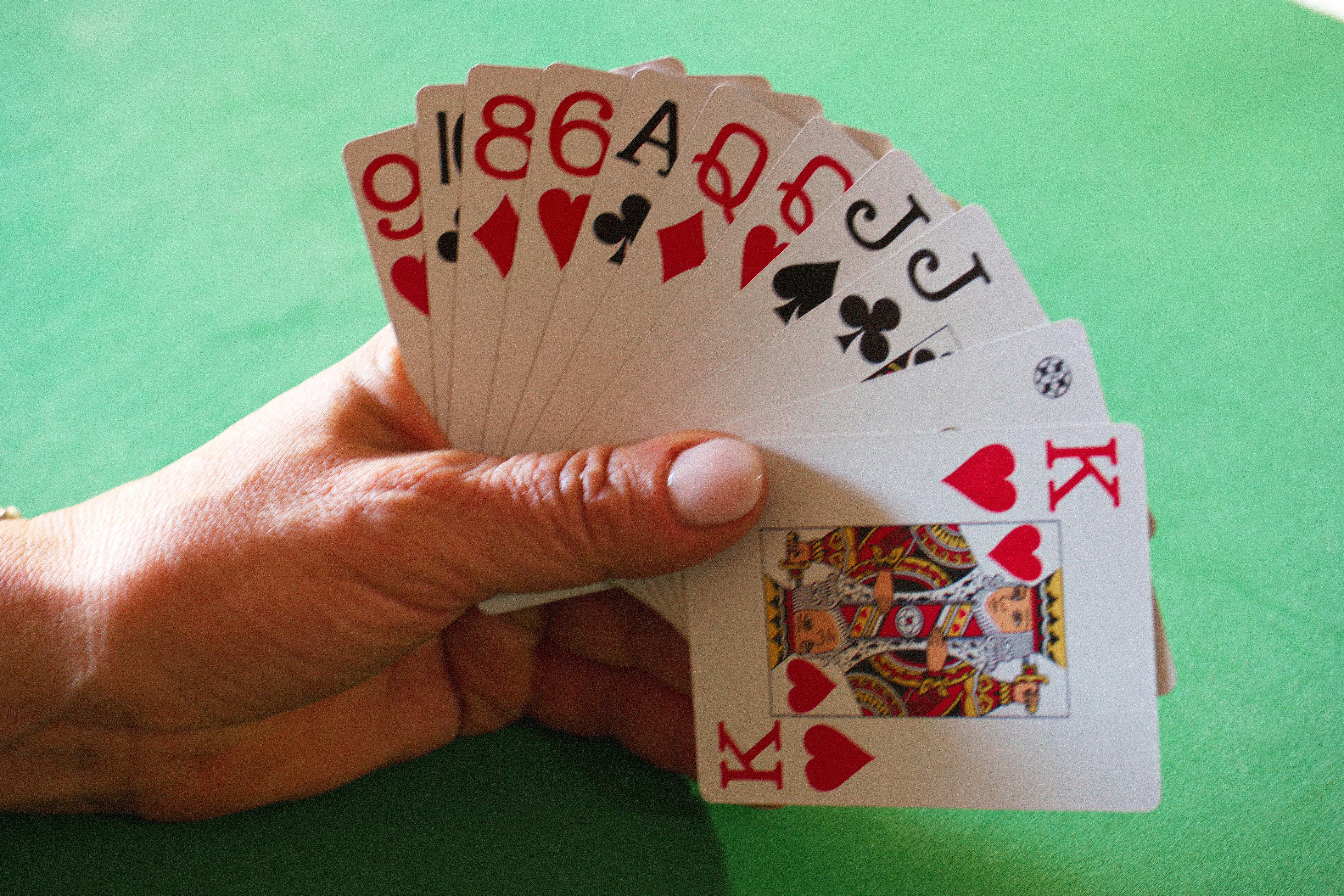 a person holding four playing cards in their hand