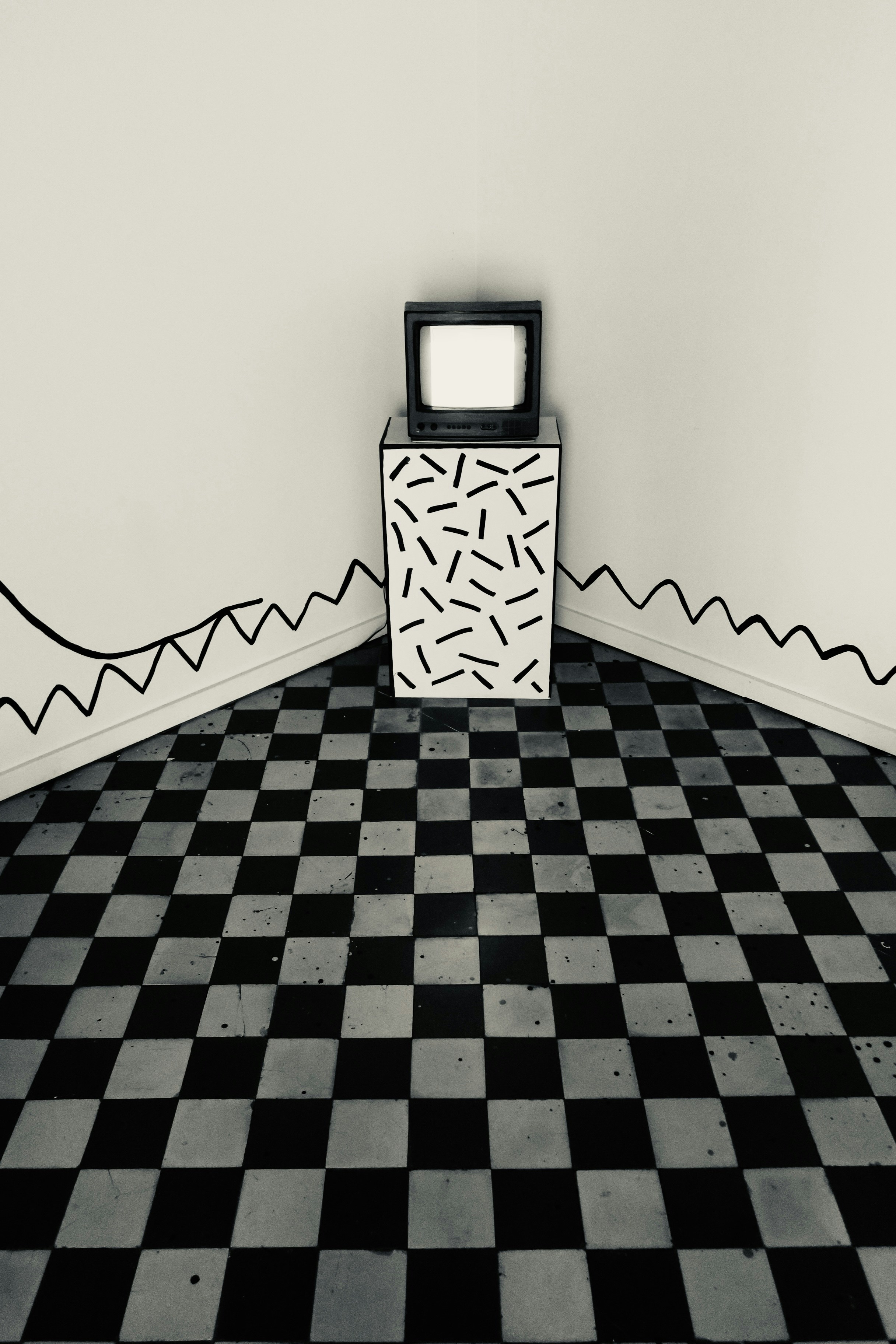 A TV sitting on top of a black and white checkered floor