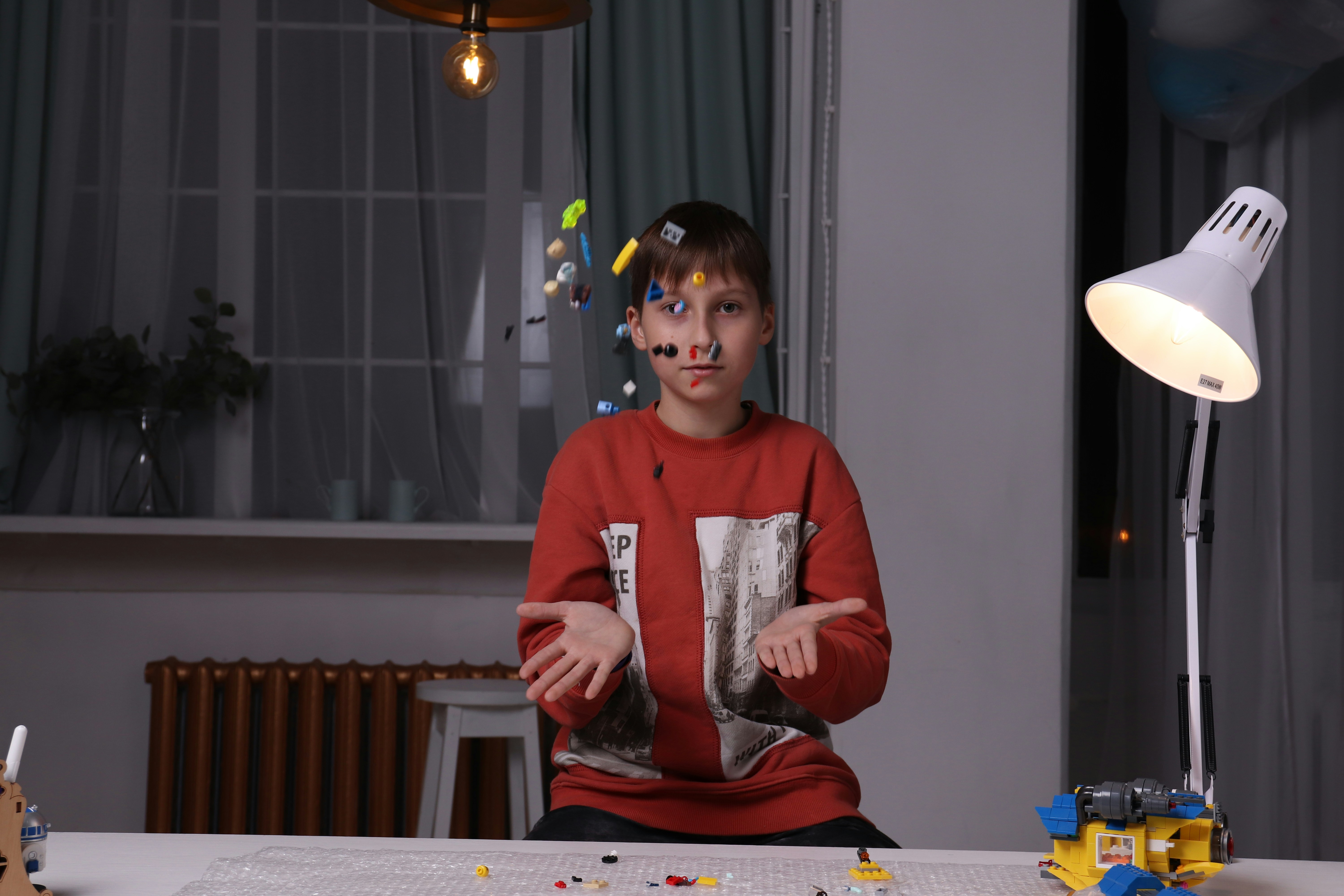 a young boy sitting at a table with legos on it