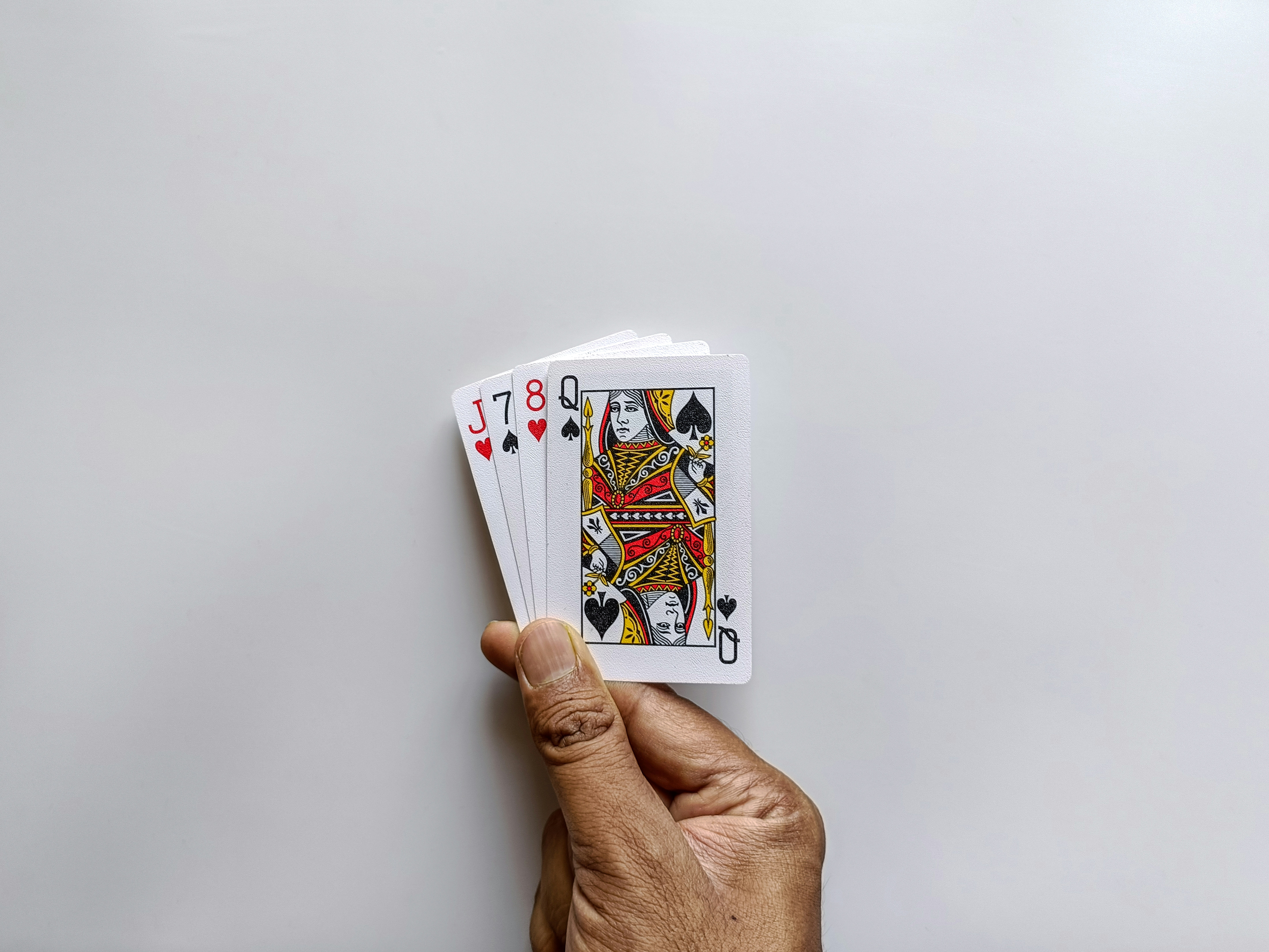Hand holding a small stack of playing cards.