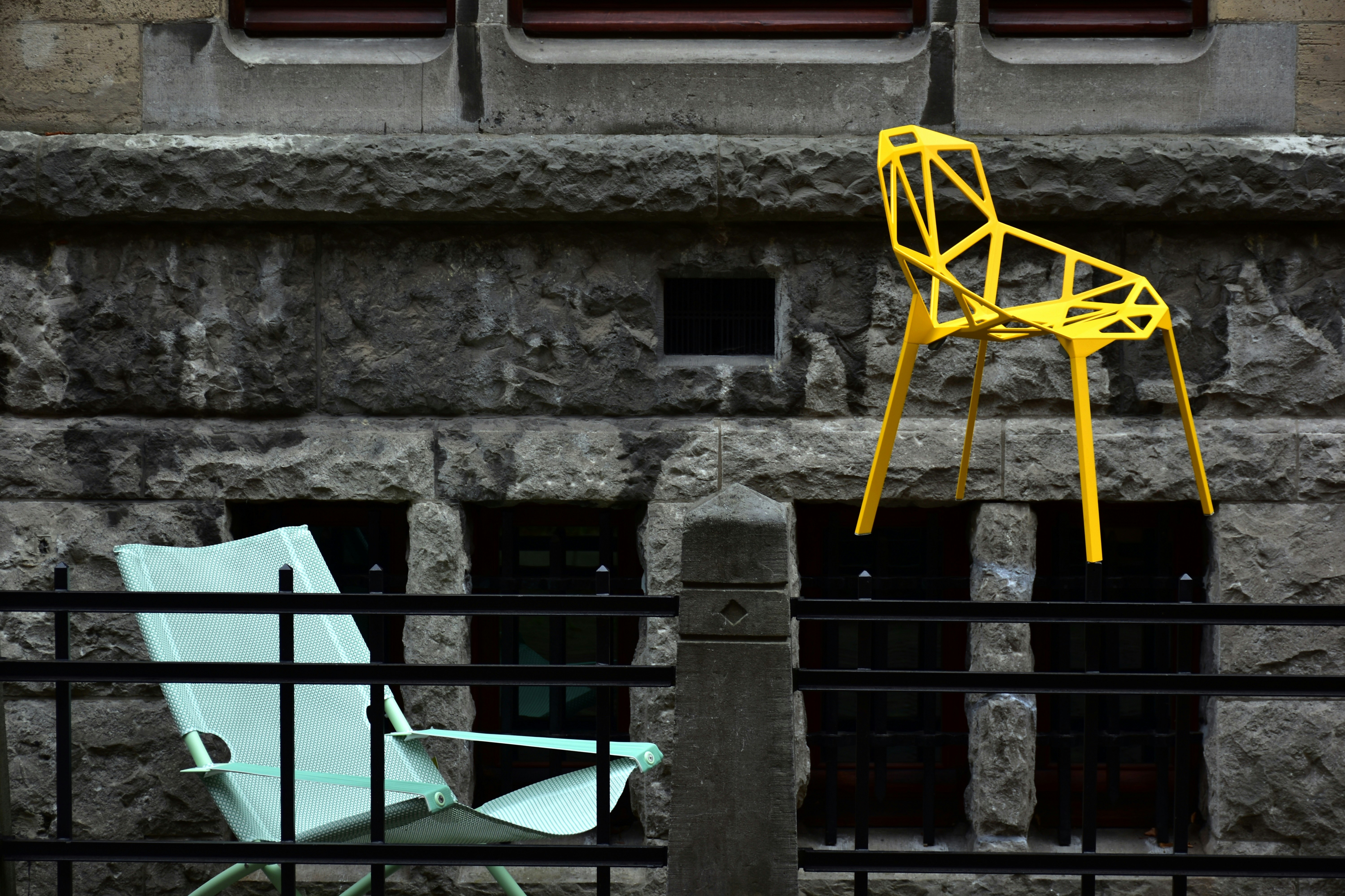 a yellow chair sitting on top of a cement wall