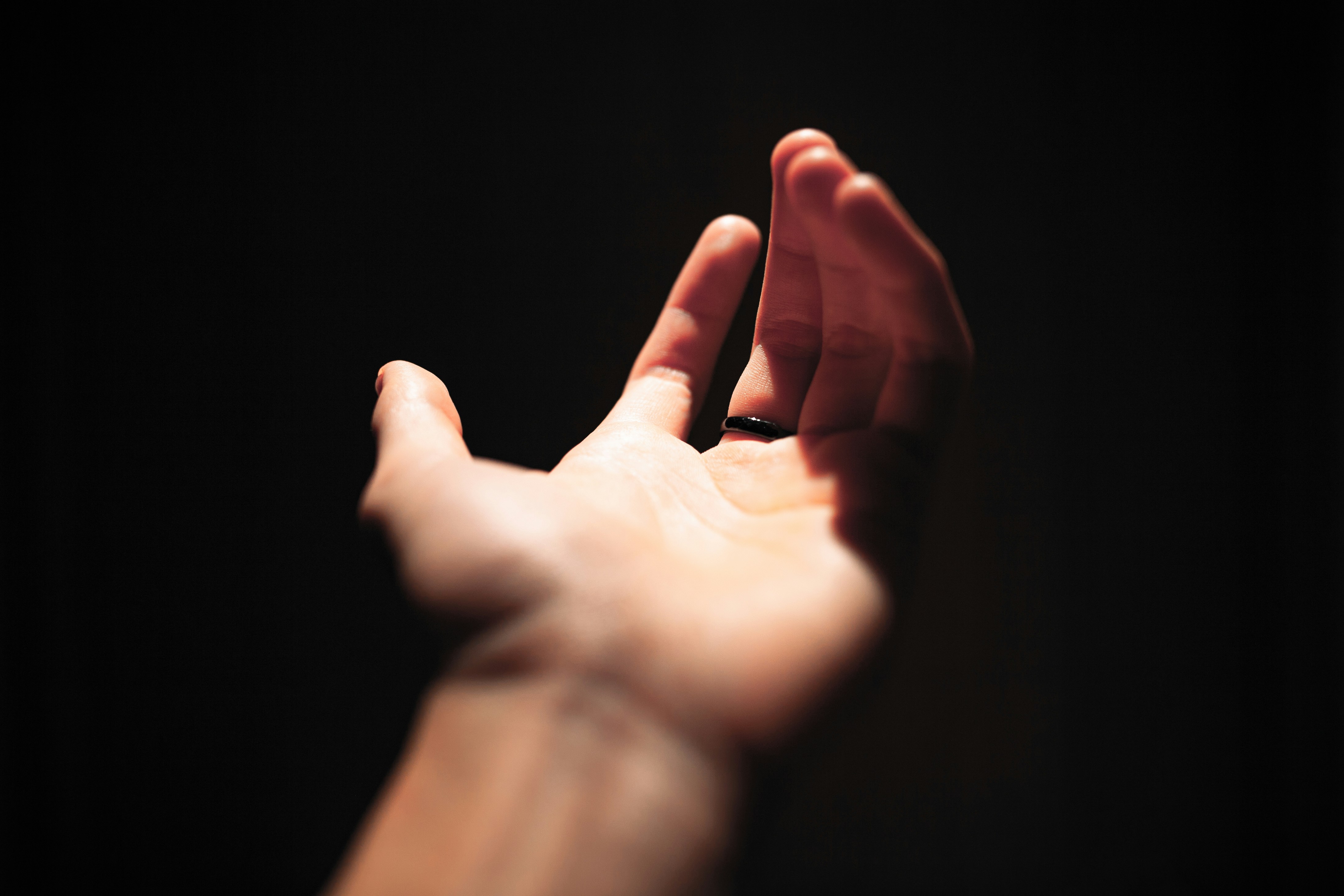 a person's hand reaching up into the air