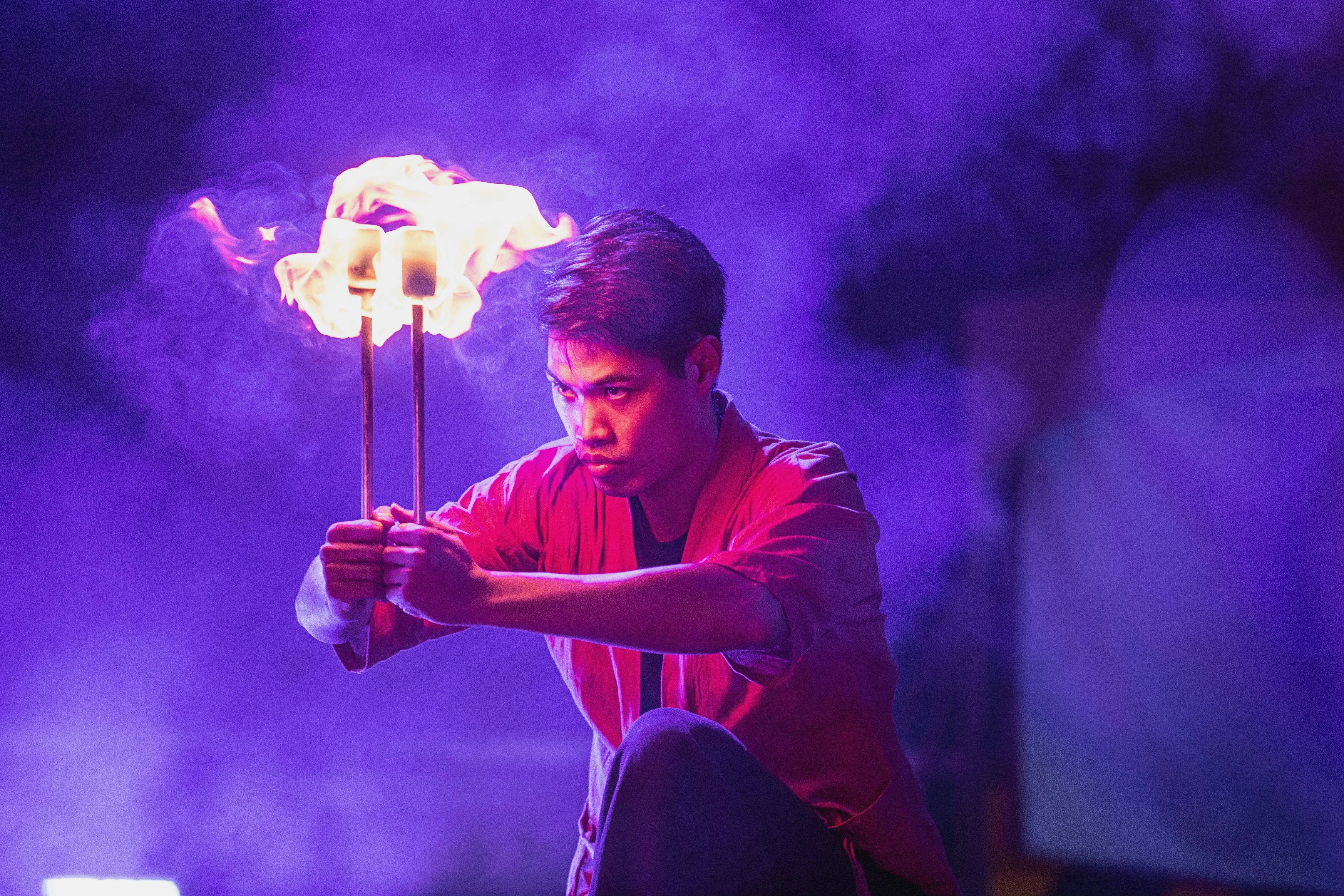 Dance of fire by Magic Trick A man holding a stick in front of a purple light