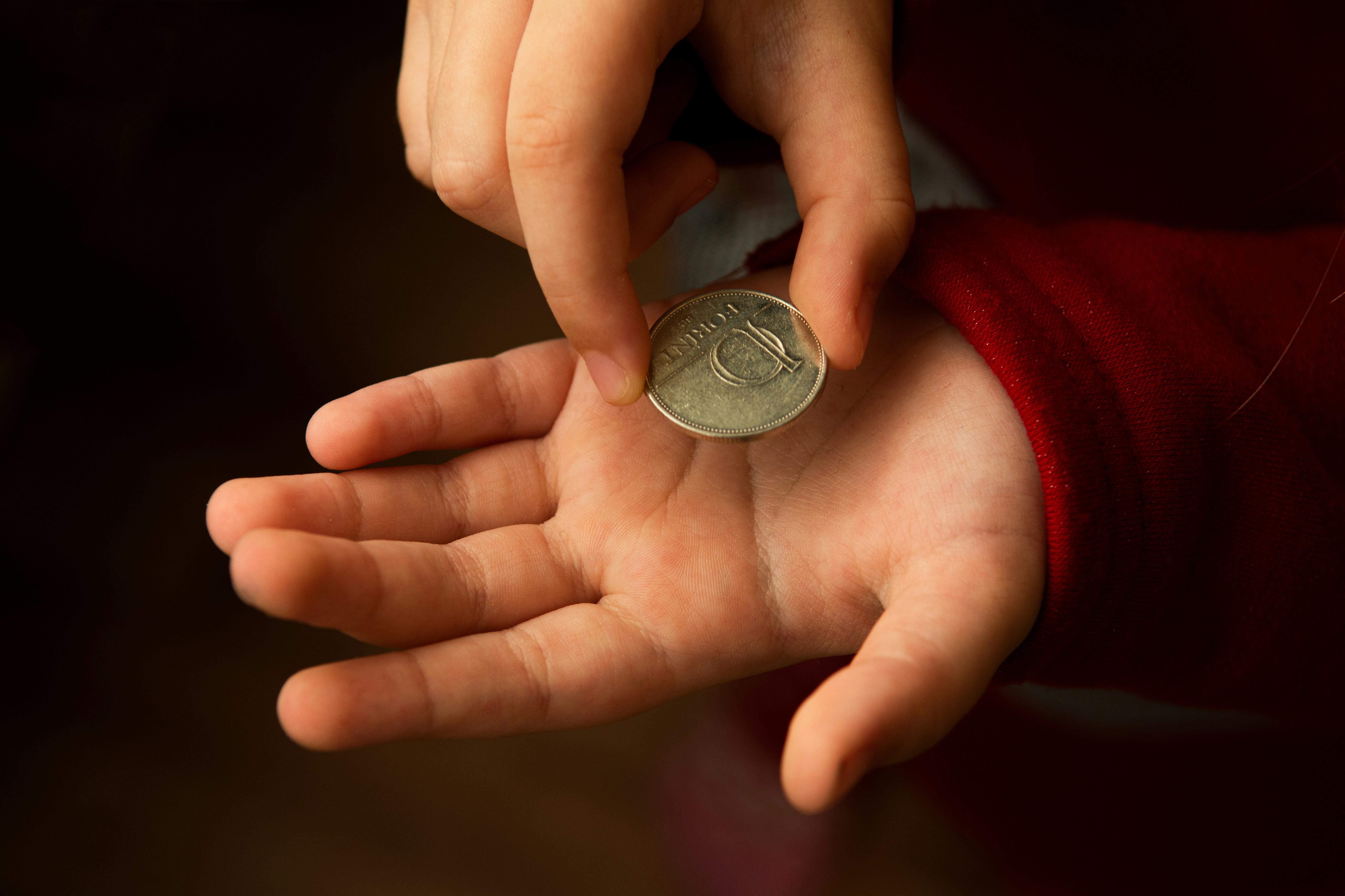 silver round coin on persons hand