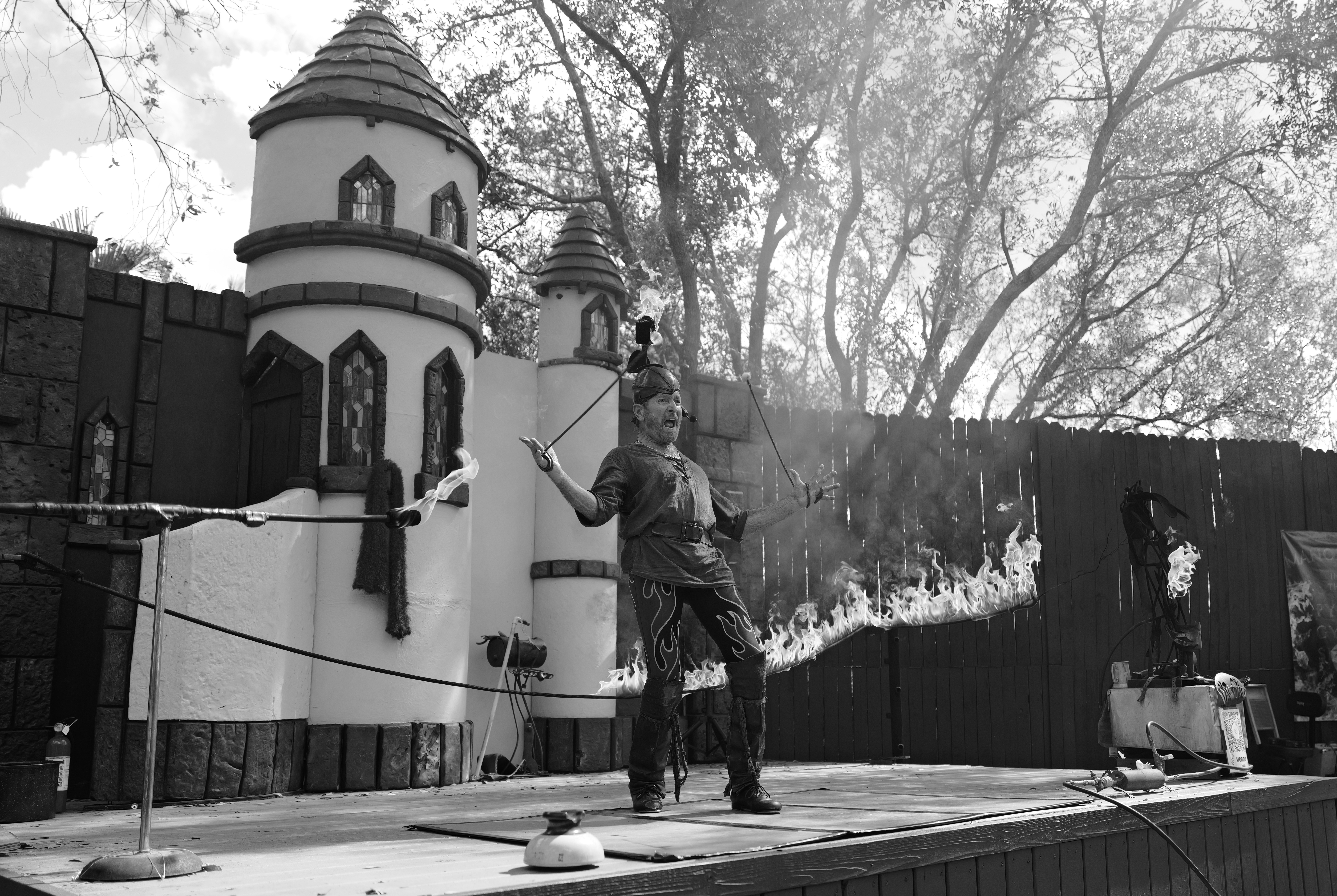 A man doing a stunt. by Magic Trick A man standing on a stage in front of a building