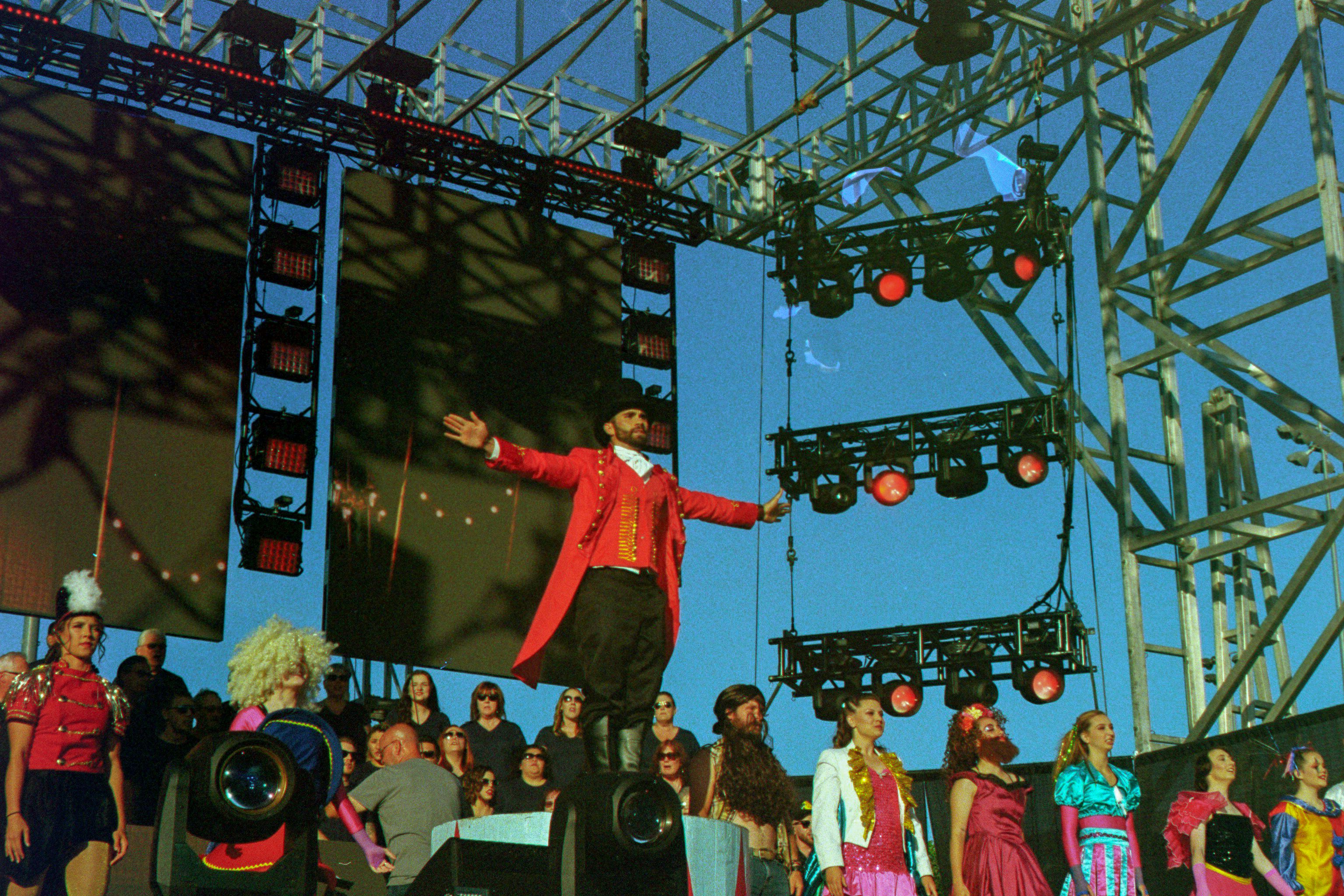 FAQ by Magic Trick man in red coat standing in front of crowd