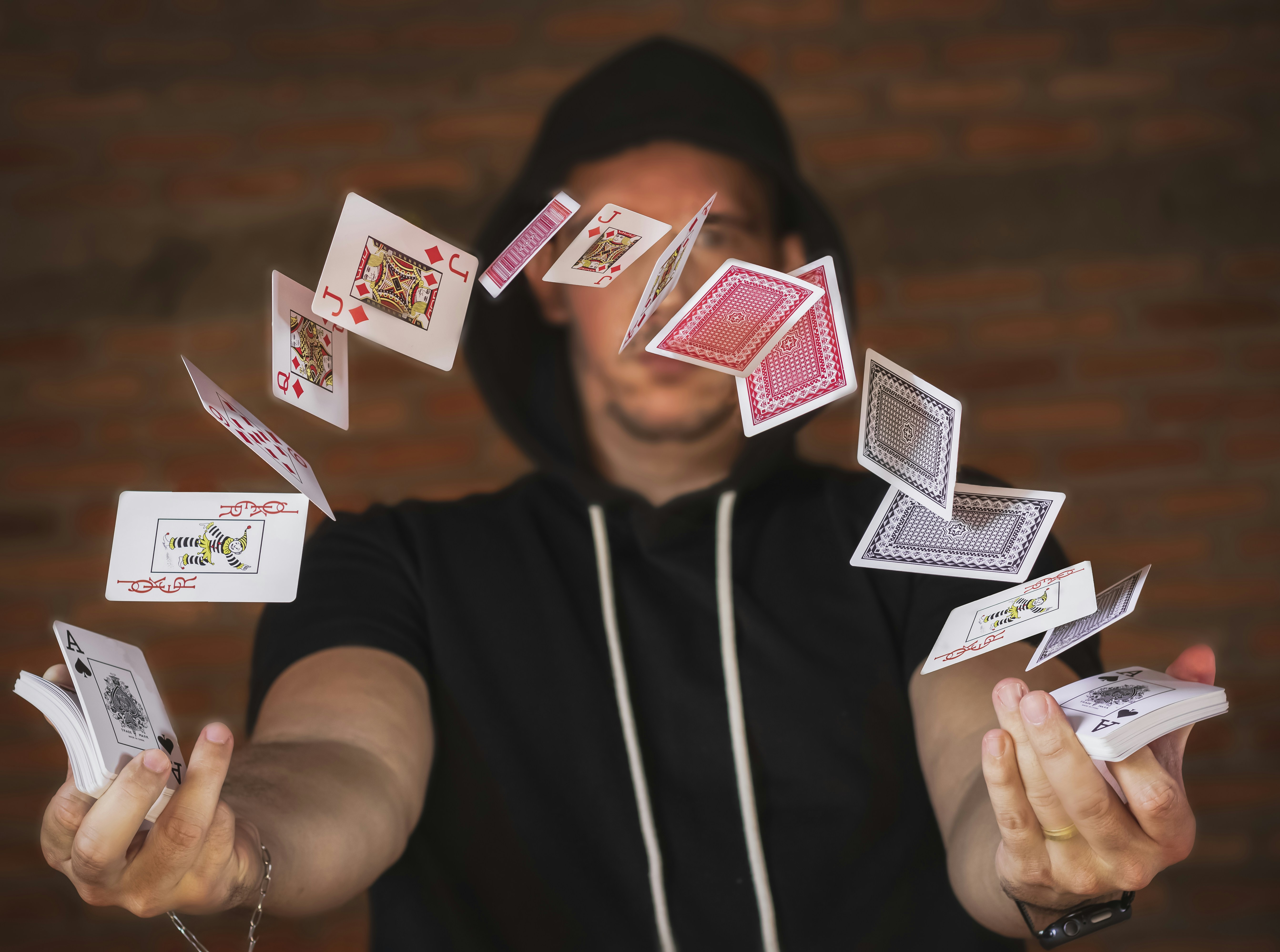Plying with decks of cards by Magic Trick woman in black and white crew neck t-shirt holding playing cards