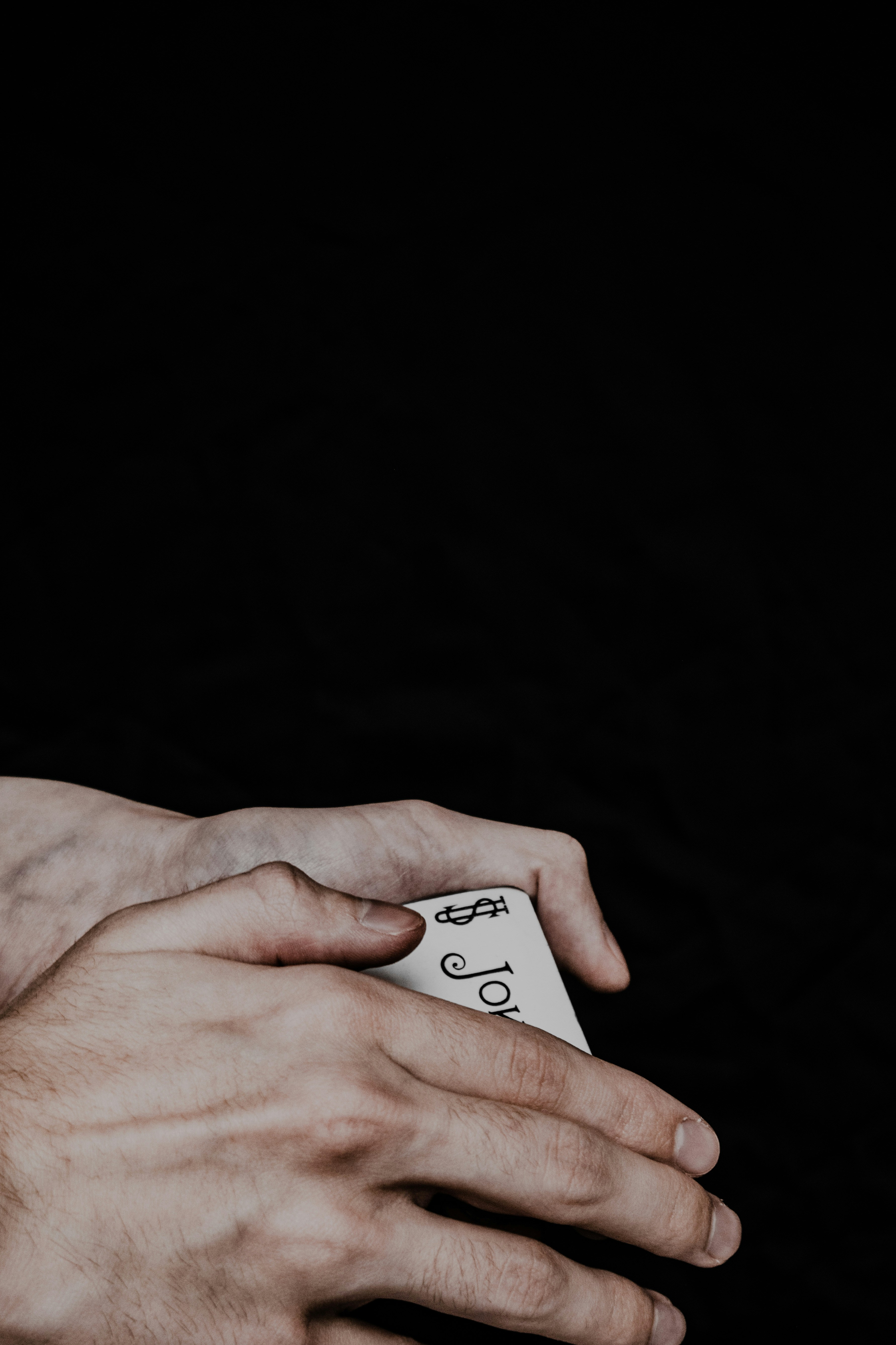 Playing cards Joker by Magic Trick a person holding a remote control in their hands