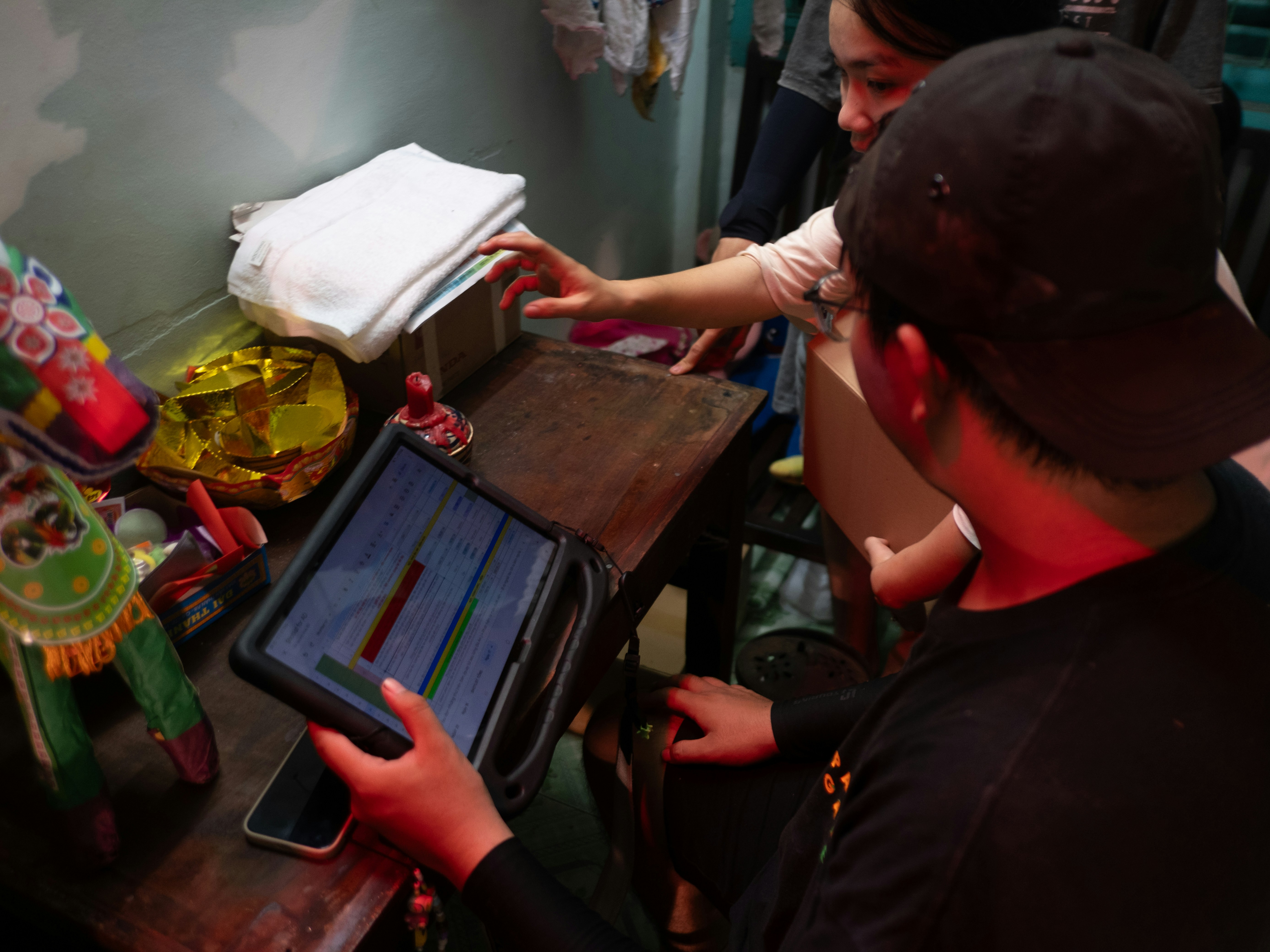 Two people using a tablet near various household items