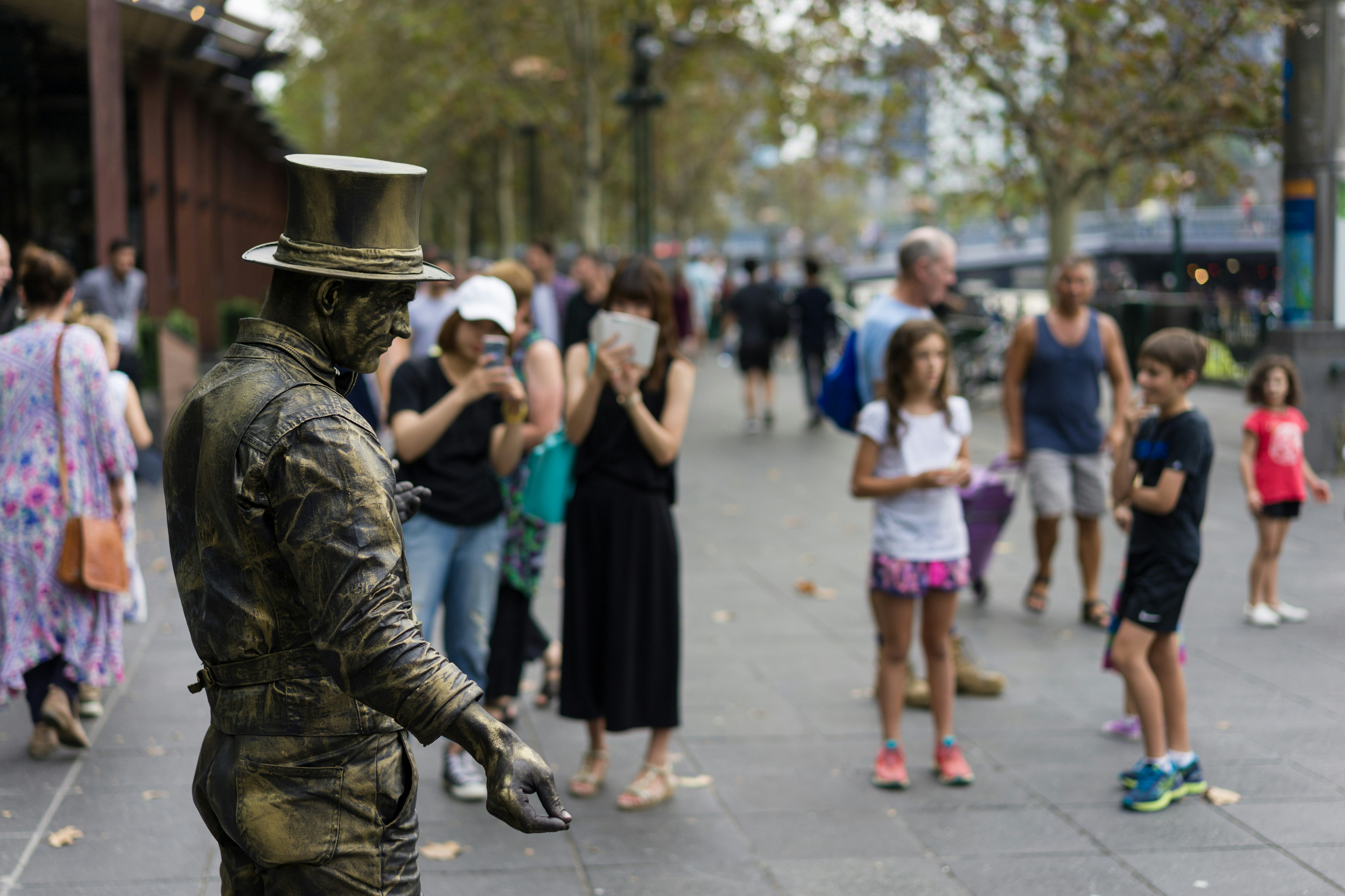 A street performer dressed as a statue entertains onlookers