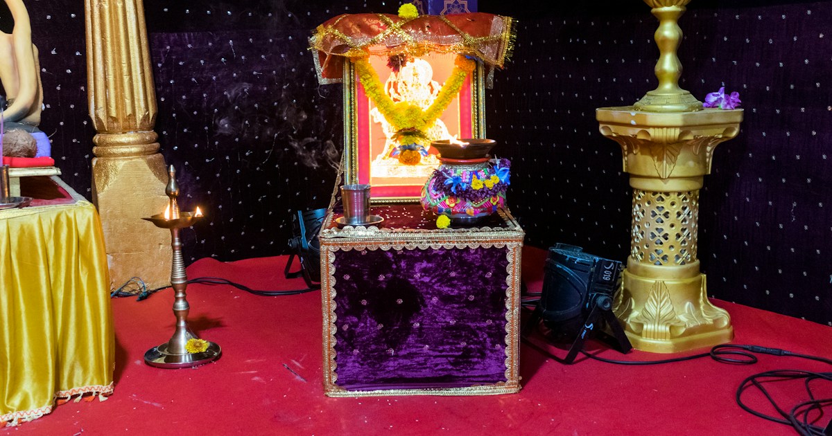 A beautiful photo of Maa Durga being worshipped at a Hindu temple in Mumbai, India for the festival of Navratri or Durga Puja by Magic Trick Decorated altar with deity and offerings