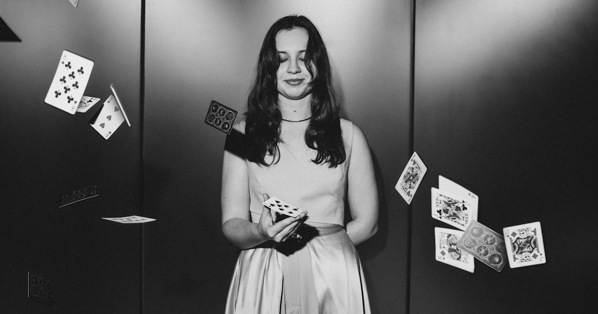 Magic Trick by Magic Trick A young woman with cards falling around her