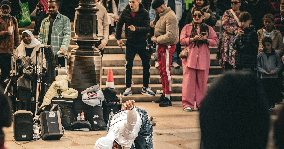 What role did street performers and traveling magicians play in the evolution of magic tricks? by Magic Trick a person doing a trick on a skateboard in front of a crowd